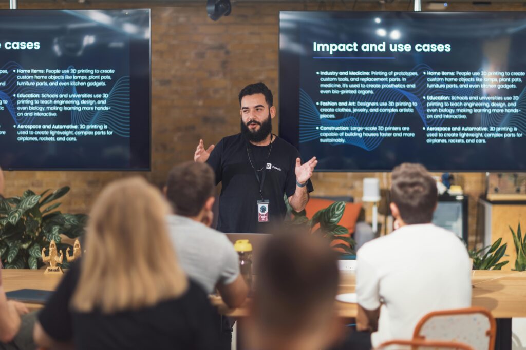 pexels-photo-29253461-29253461 Professional speaker discusses 3D printing applications with attentive audience in tech seminar.