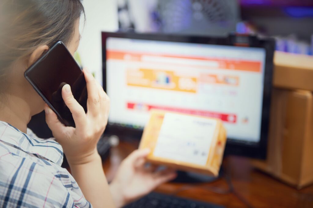 woman use mobilephone after recive box from online shopping. selective focus